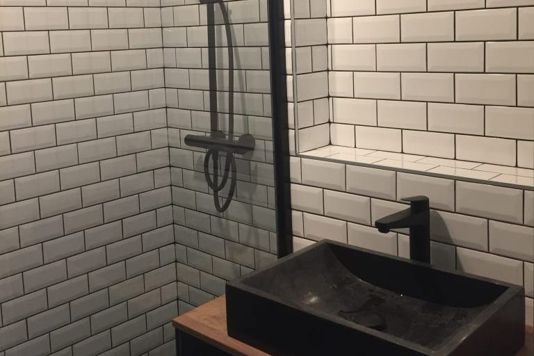 Faïence métro blanche et vasque en pierre noire, finition de salle de bains