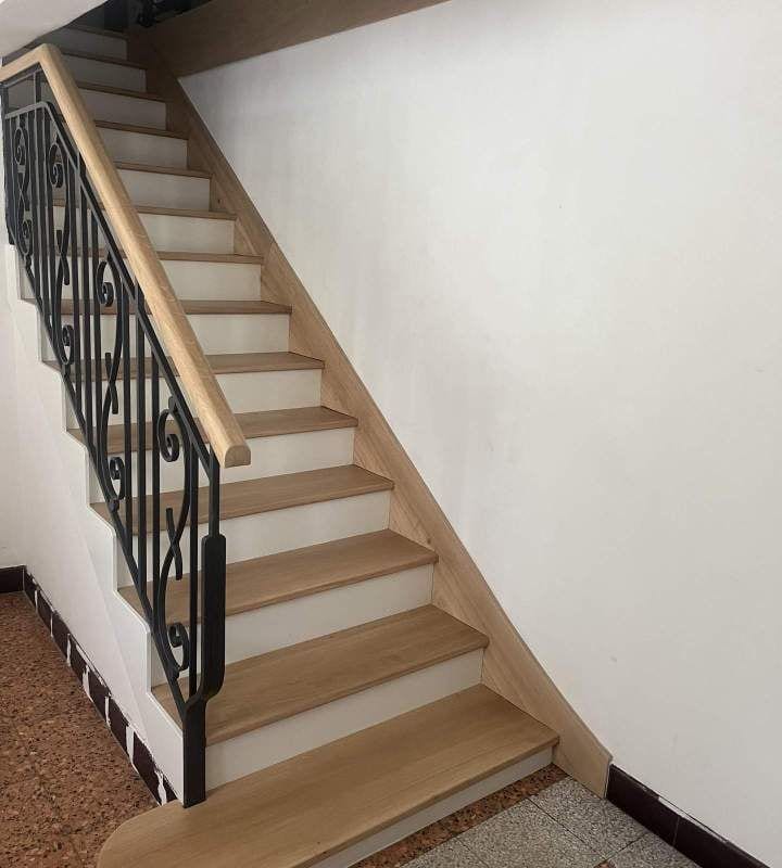 Escalier intérieur rénové en chêne avec sa rampe en fer forgé conservée