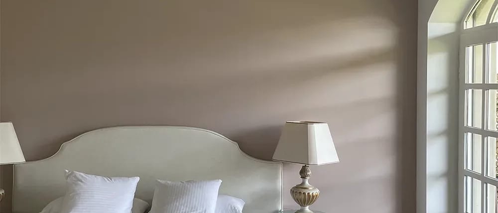 Chambre repeinte en taupe avec plafond blanc et fenêtre cintrée
