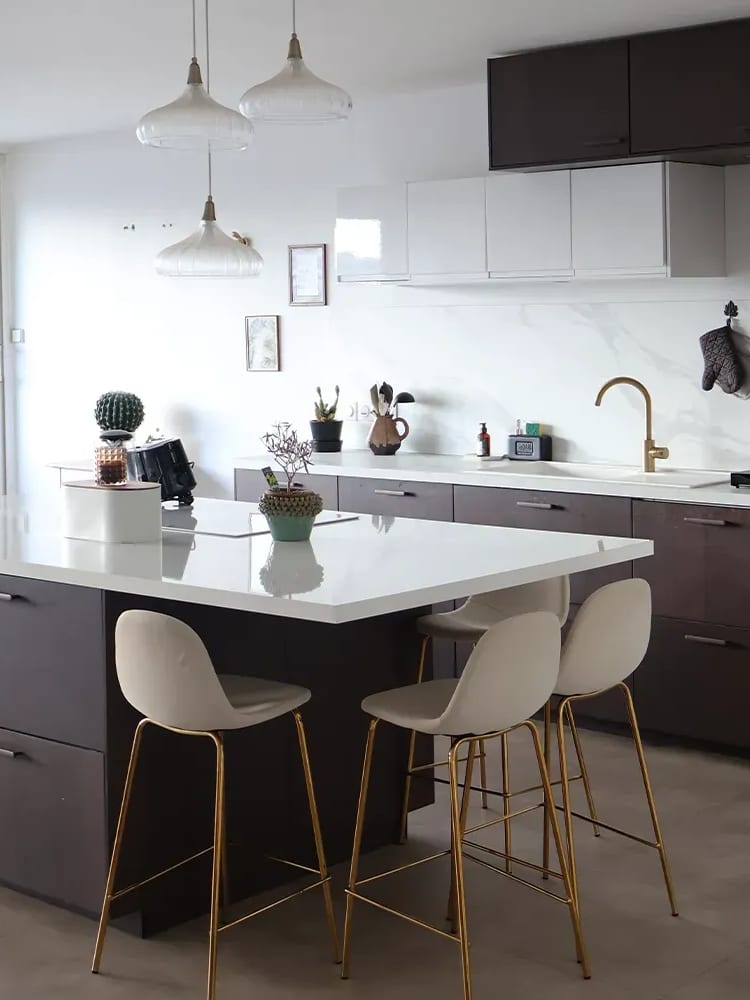 Cuisine équipée avec îlot central et tabourets après rénovation complète